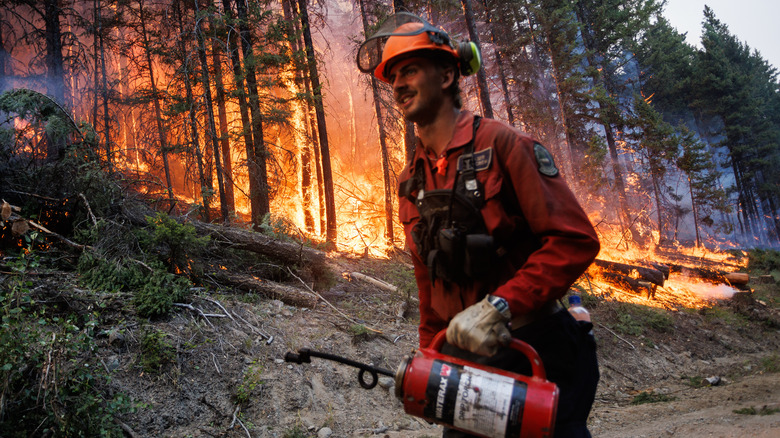 Firefighter walks by fire