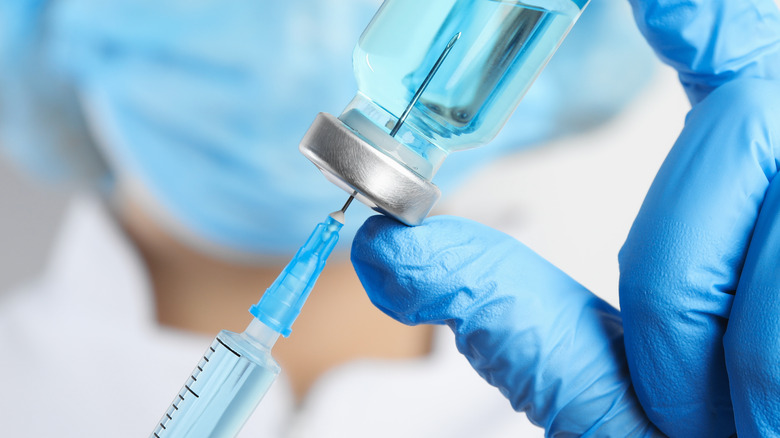 doctor holding syringe vial