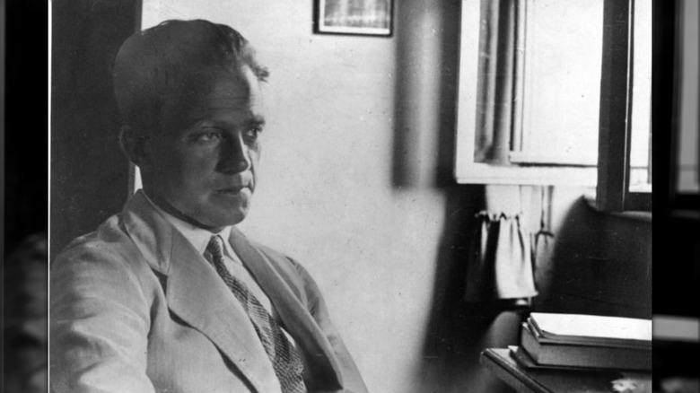 Werner Heisenberg sitting at a desk staring into space
