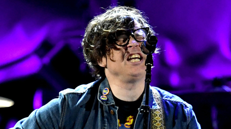 ryan adams singing at microphone with eyes closed