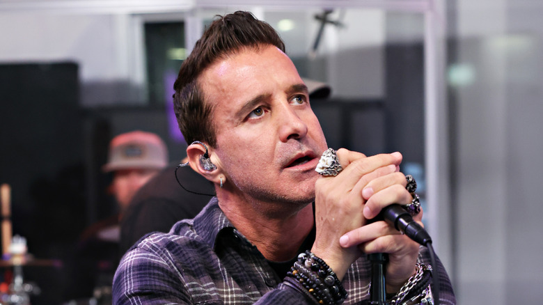 scott stapp clutching microphone and gazing upward