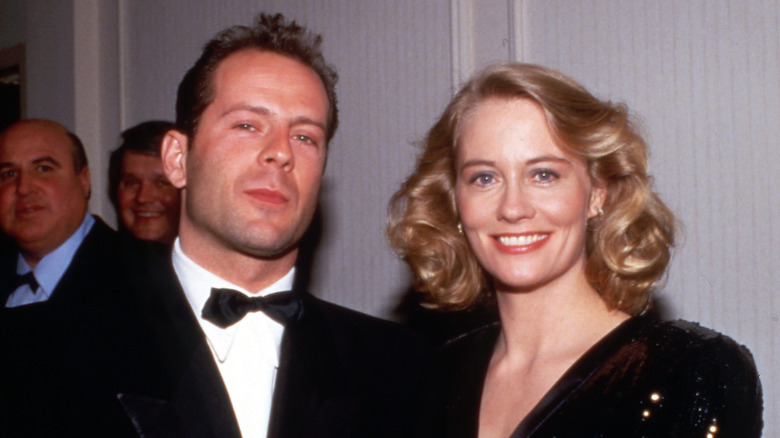 Bruce Willis squinting and Cybil Shepherd smiling at event