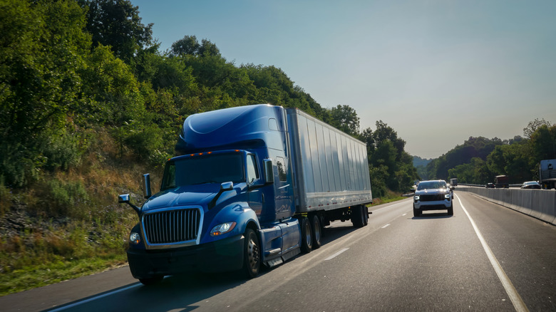 Vehicle driving alongside a semi-truck