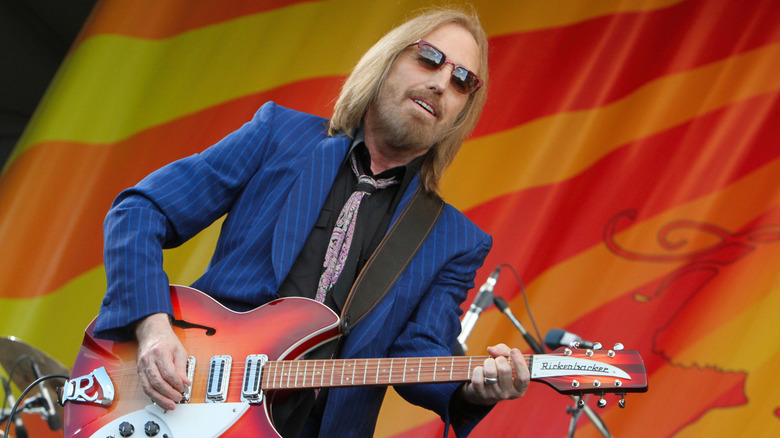 Tom Petty on stage with a guitar.