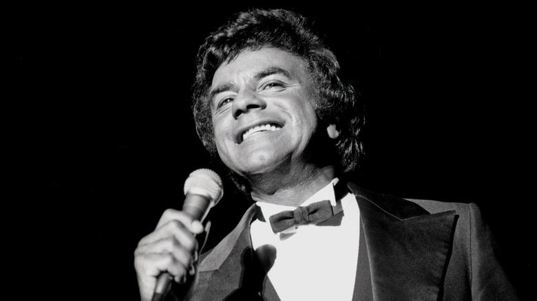 Johnny Mathis singing and smiling on stage