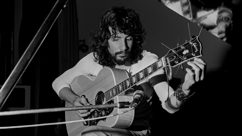 Cat Stevens tuning his guitar