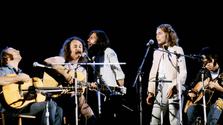 Joni Mitchell performing on stage with Crosby, Stills, Nash, & Young ca. 1973.