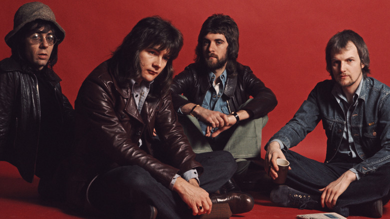 Manfred Mann's Earth Band posing in front of a red backdrop