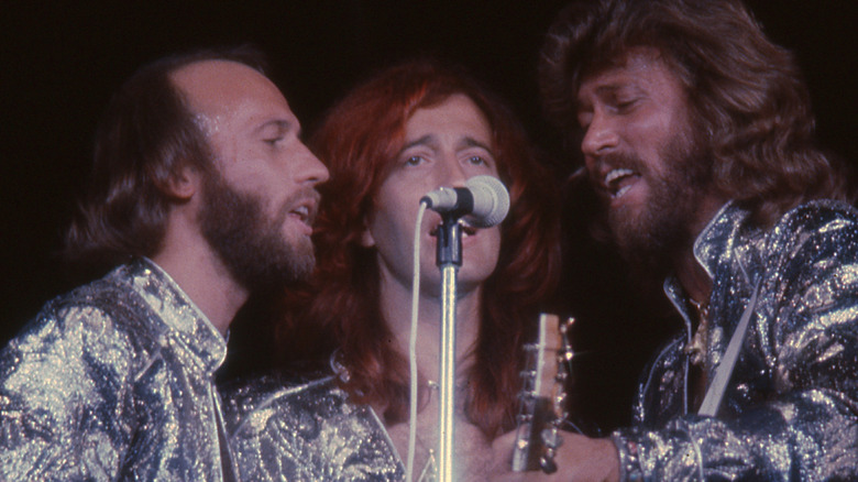 Bee Gees sharing a microphone onstage