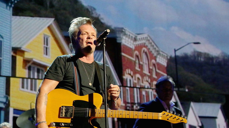 John Mellencamp playing the guitar.