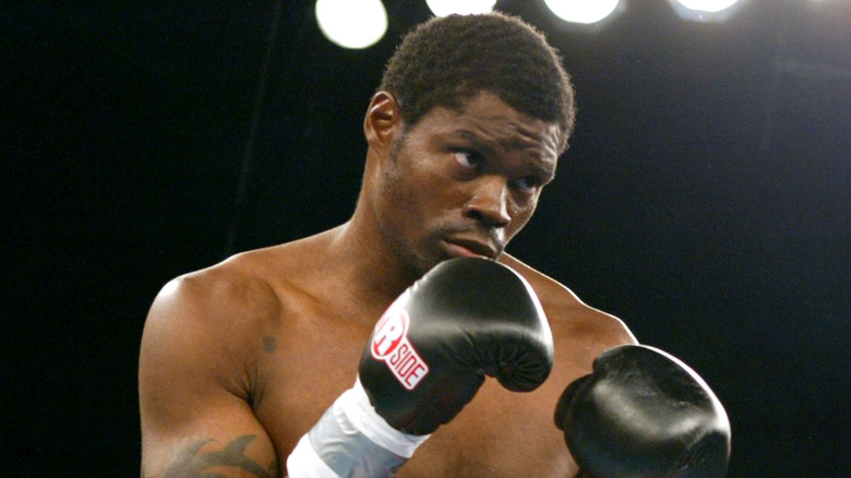 James Butler in ring black boxing gloves
