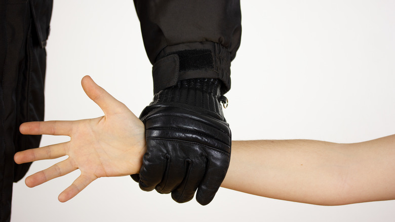 Gloved hand holding arm