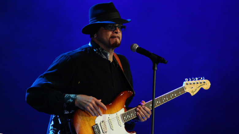 Sinbad playing guitar onstage