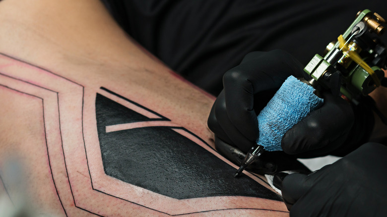 Tattoo artist inking a tattoo