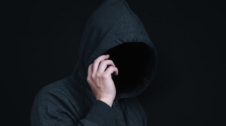 hooded person talking on phone