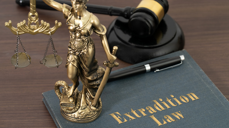 gavel, lady justice statue, folder marked extradition law