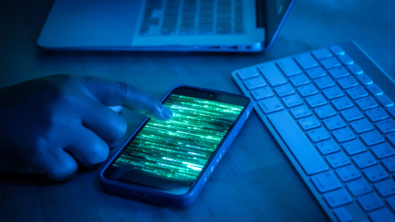 phone with green static surrounded by keyboards
