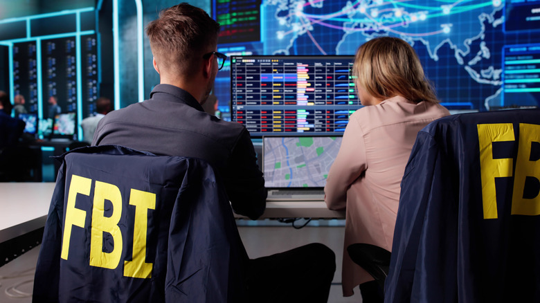 FBI agents looking at computer screen in office