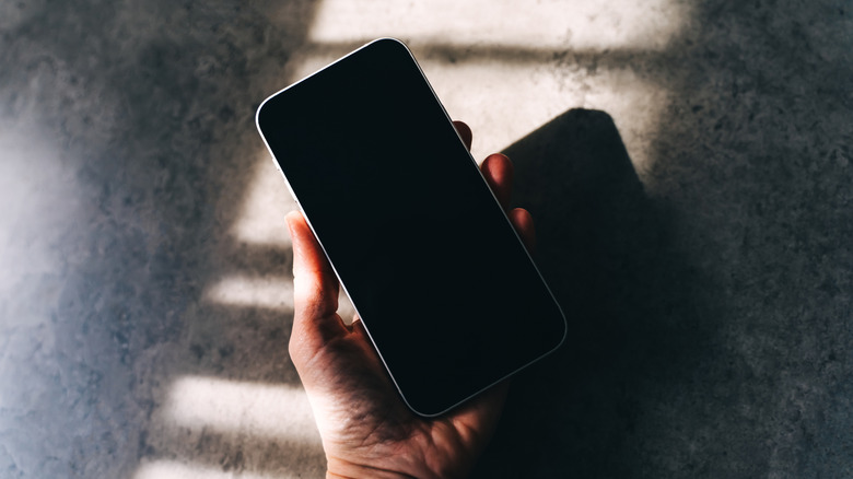hand holding iphone that's off