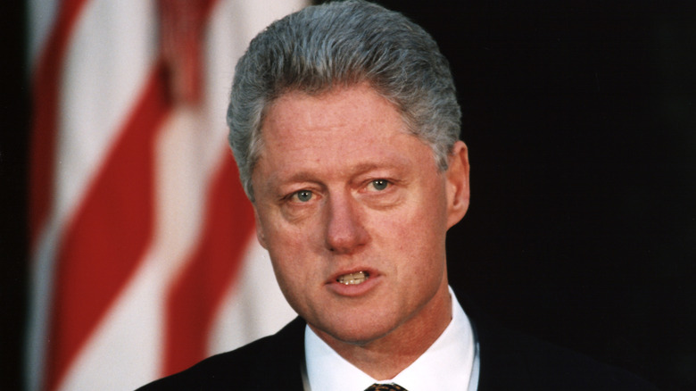 Bill Clinton talking in front of flag