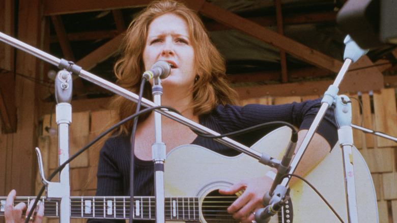 Bonnie Raitt singing with guitar