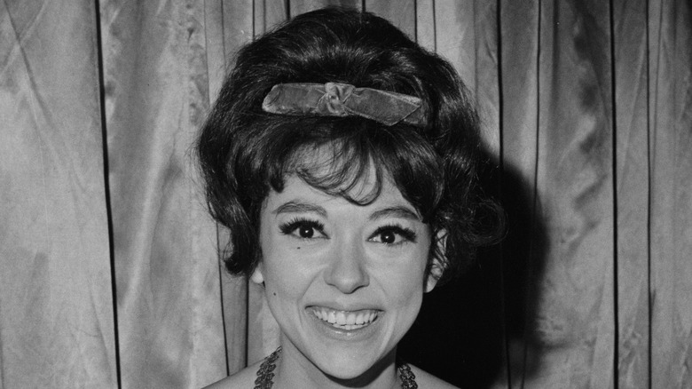 Rita Moreno smiling with West Side Story merchandise