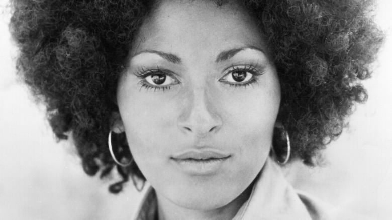 Pam Grier looking in hoop earrings