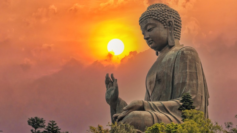 Buddha statue with sun behind