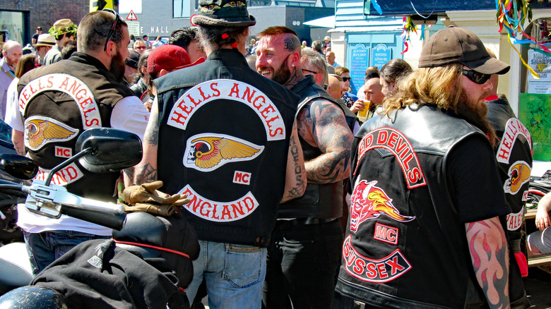 Three Hells Angels from back with patches on vests