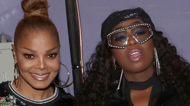 Janet Jackson smiling with Missy Elliott wearing jeweled glasses