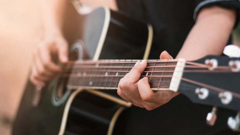 Person playing acoustic guitar