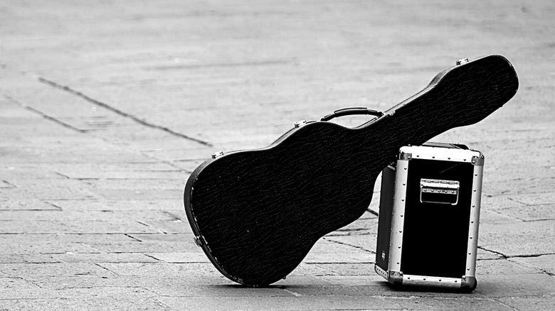 Hard-cased guitar leaning against box