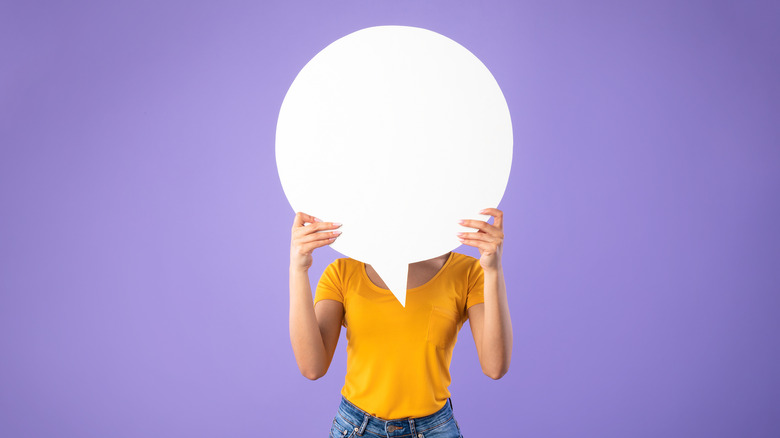 a woman holds something in front of her face