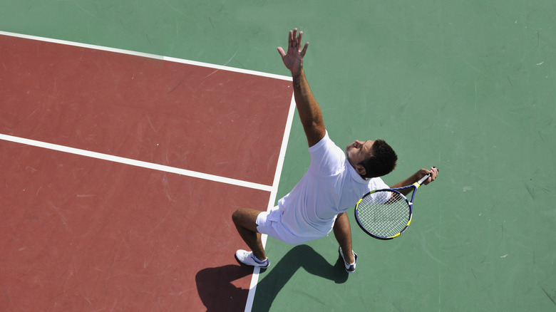 Player serving on tennis court