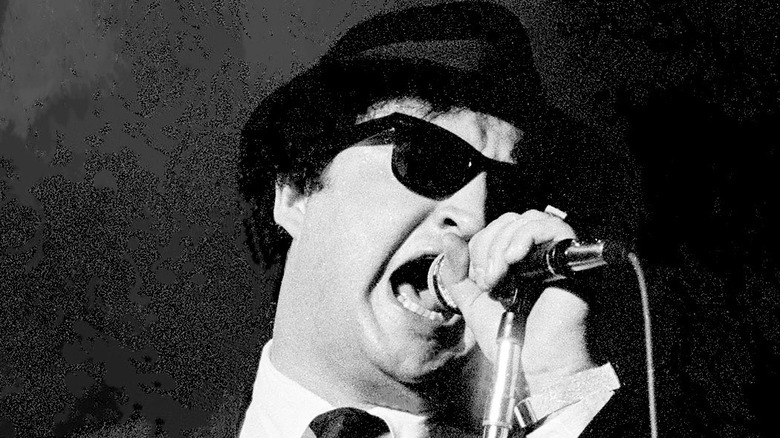 John Belushi singing into microphone