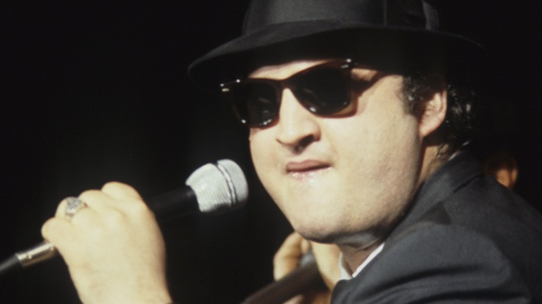John Belushi singing into microphone