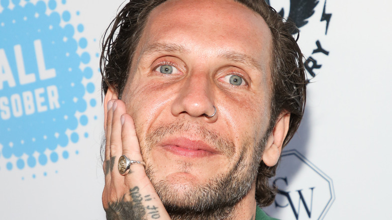 Brandon Novak smiling hand on cheek stubble