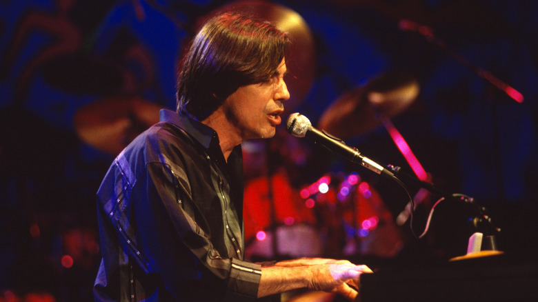 Jackson Browne singing and playing piano on stage