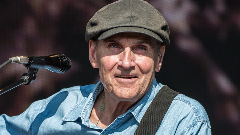 James Taylor smiling as he looks into crowd at concert