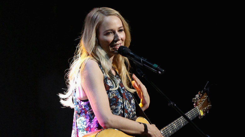 Jewel speaks into microphone onstage