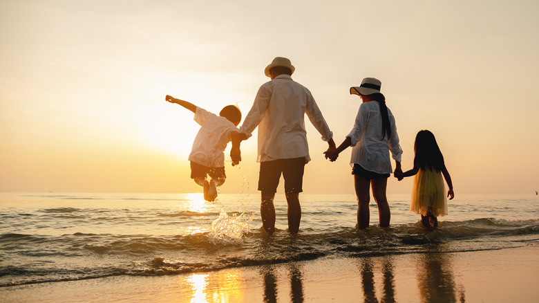 Family standing at the edge of ocean