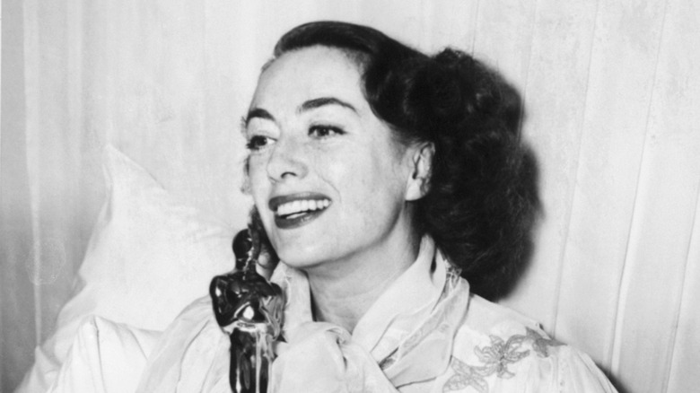 joan crawford posing in bed with oscar for Mildred Pierce