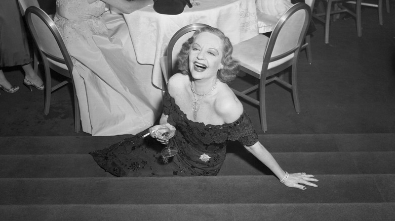 tallulah bankhead seated on steps with a cocktail