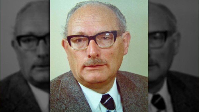 Johan van Hulst wearing glasses and a grey suit