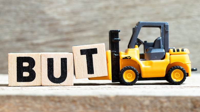 Toy forklift taking away word "But"