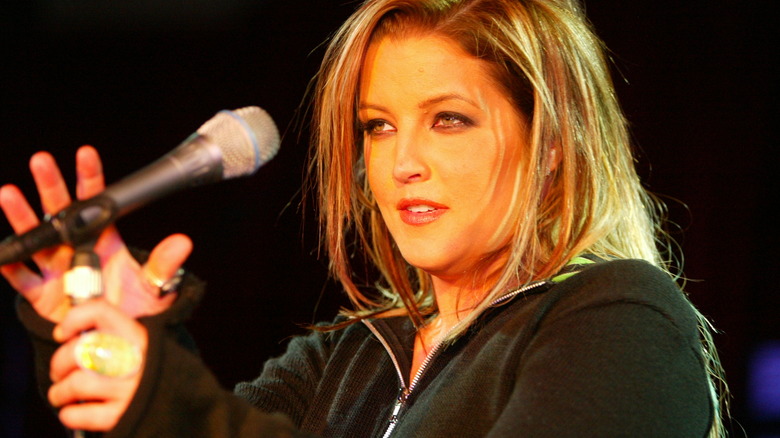 Lisa Marie Presley adjusts a microphone