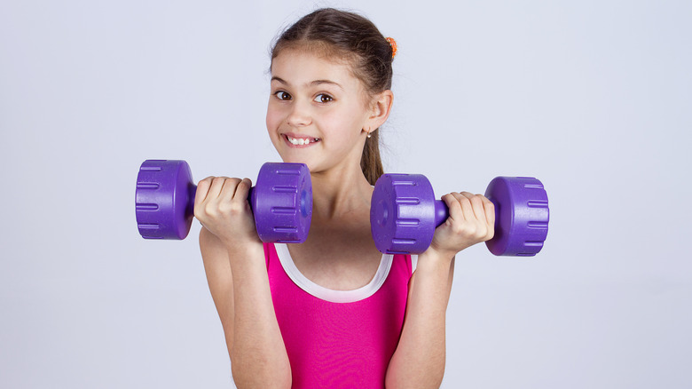 girl holding dumbbells