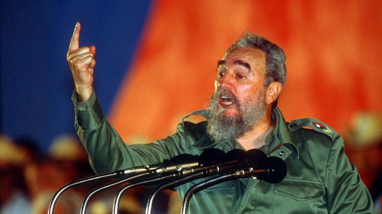Fidel castro finger raised mouth open in front of microphones