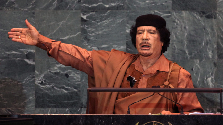 Muammar Gaddafi arm raised speaking