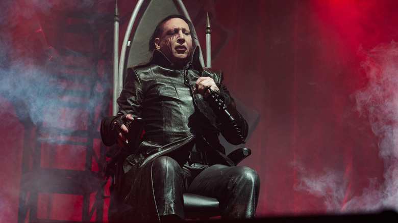Marilyn Manson sitting on a throne on stage in 2017